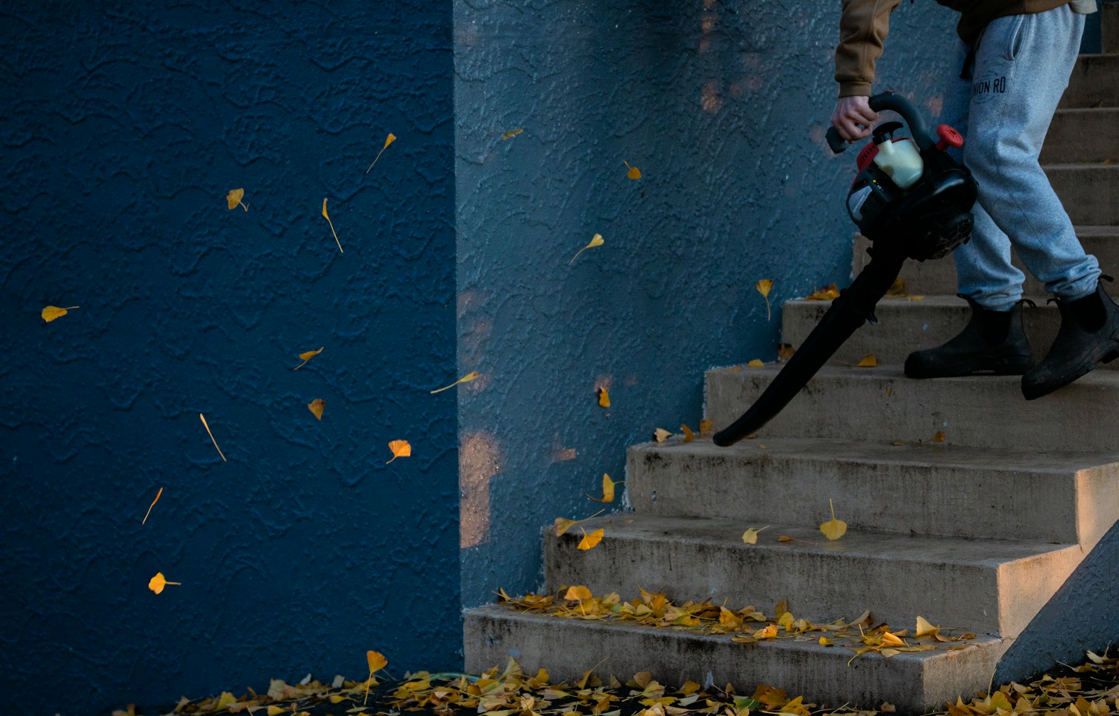 man in black jacket and pants standing on stairs